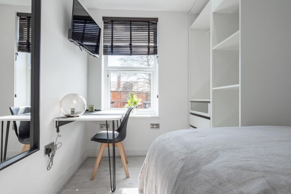 A bright and modern bedroom featuring a comfort...