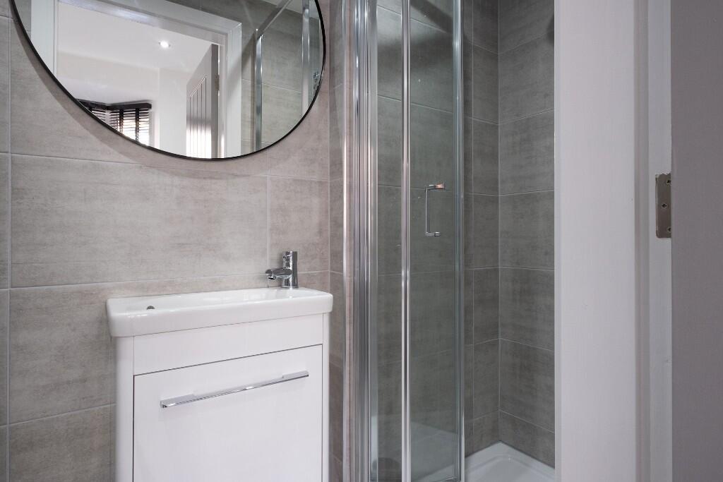 A modern, clean bathroom with a shower enclosur...
