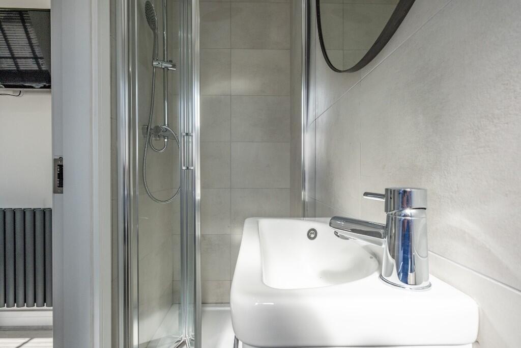 A clean and well-lit bathroom featuring a large...
