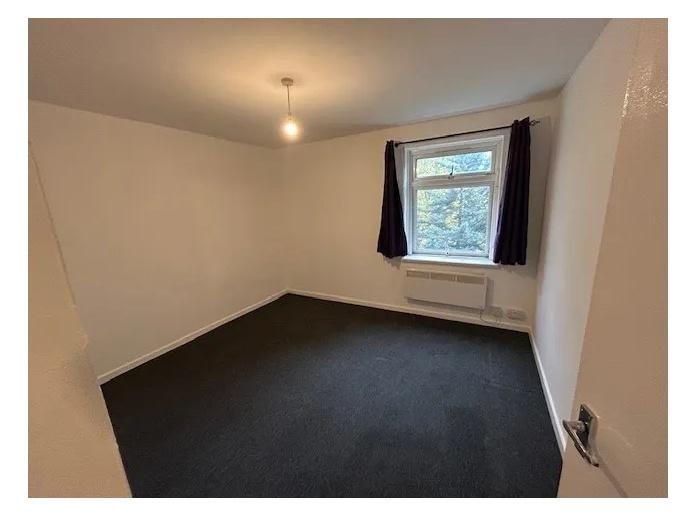 Bright, neutral bedroom with a large window, si...