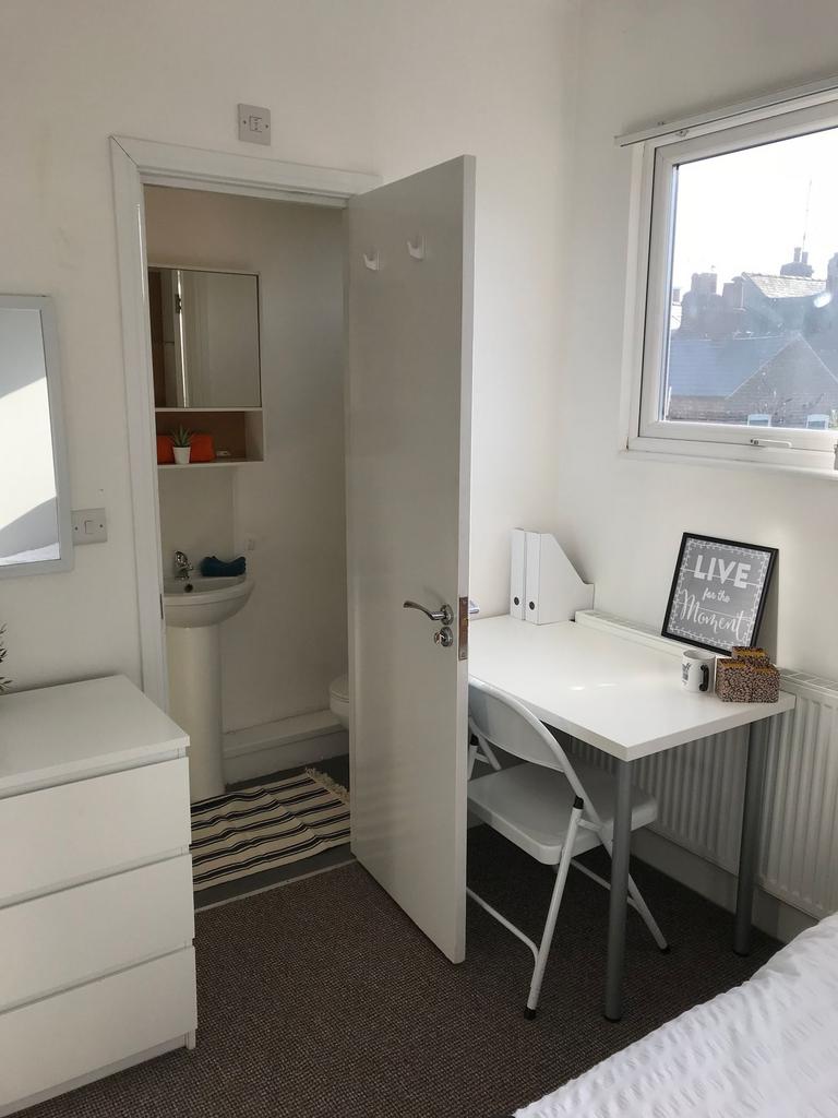 Bright, tidy bedroom with a study corner by a l...