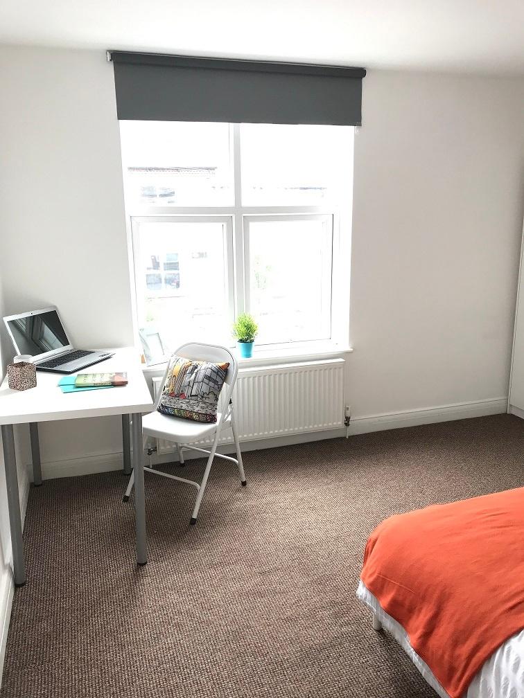 Bright, well-presented bedroom with a large win...