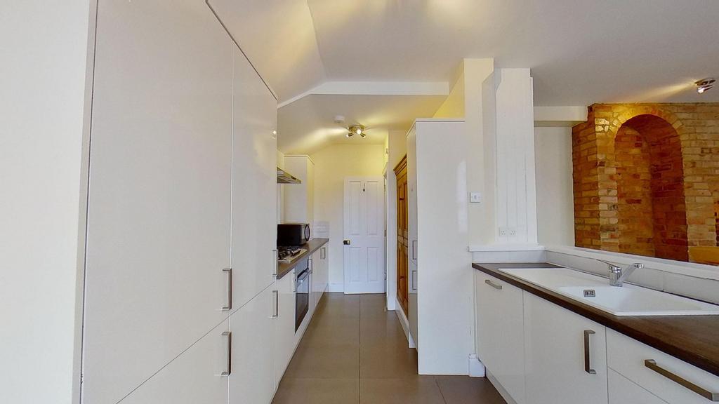 Modern galley kitchen with sleek white cabinetr...