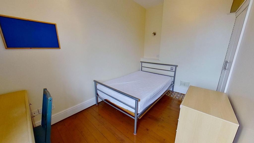 Neat single bedroom with a simple metal bedfram...
