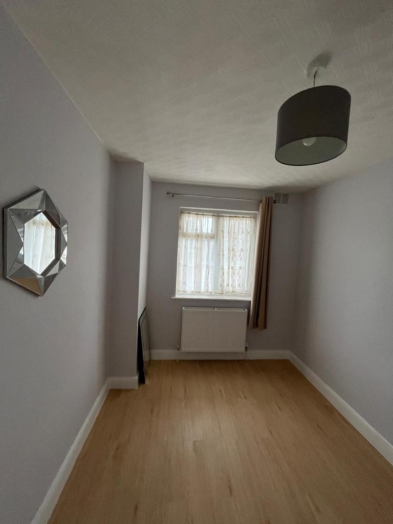 Narrow bedroom with light wood flooring, a fron...