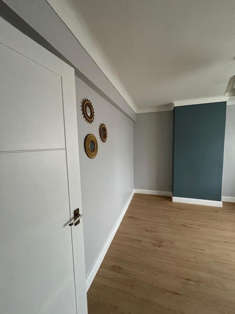 Bright, freshly painted bedroom with light wood...
