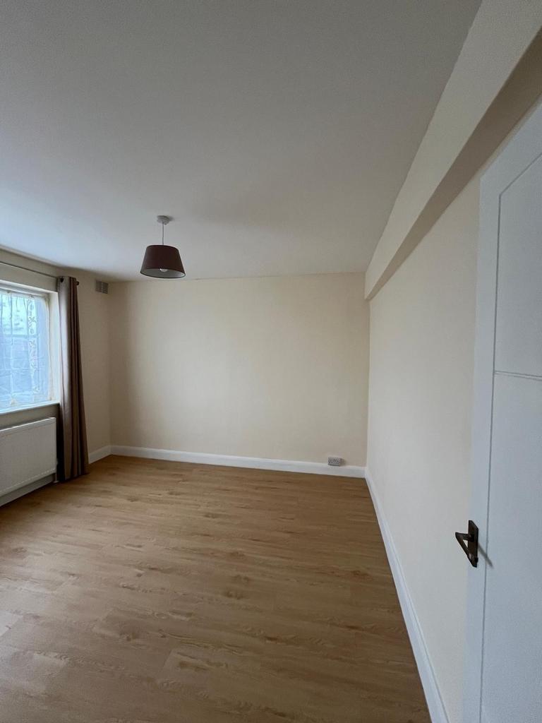 Bright, empty bedroom with wood-effect flooring...