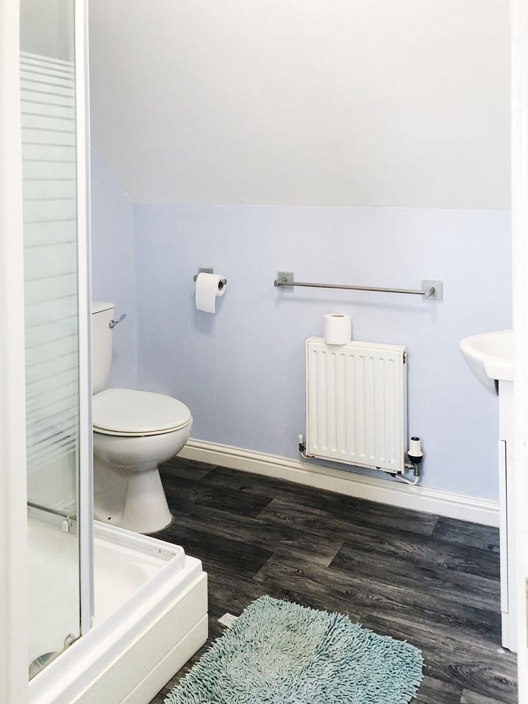 Bright, clean bathroom with a walk-in shower, t...