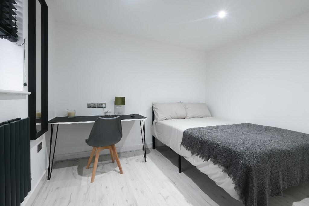 A modern, well-lit master bedroom featuring a c...