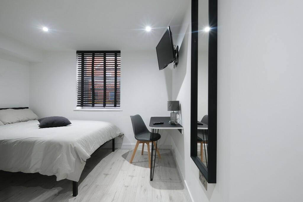 A modern, well-lit bedroom featuring a large be...