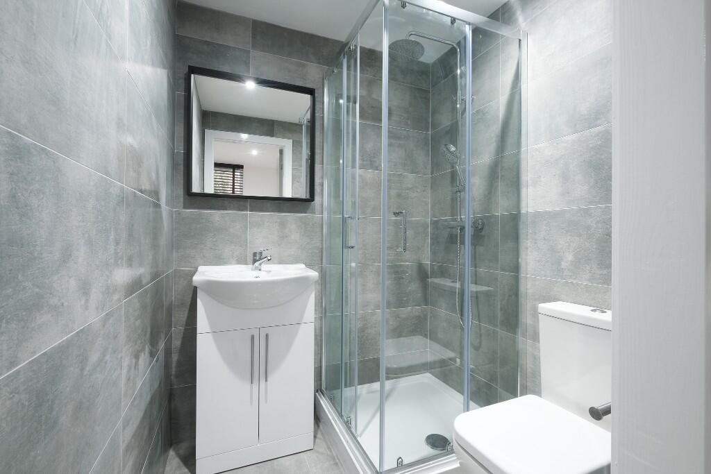 A modern, clean bathroom with a shower enclosur...