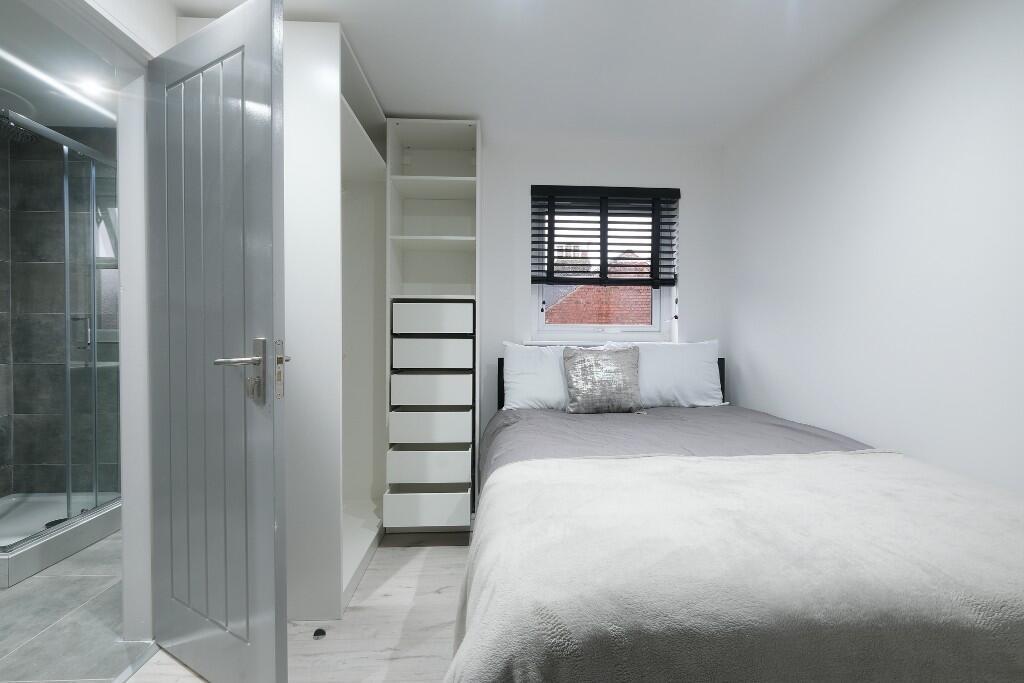 A bright and neatly maintained bedroom featurin...
