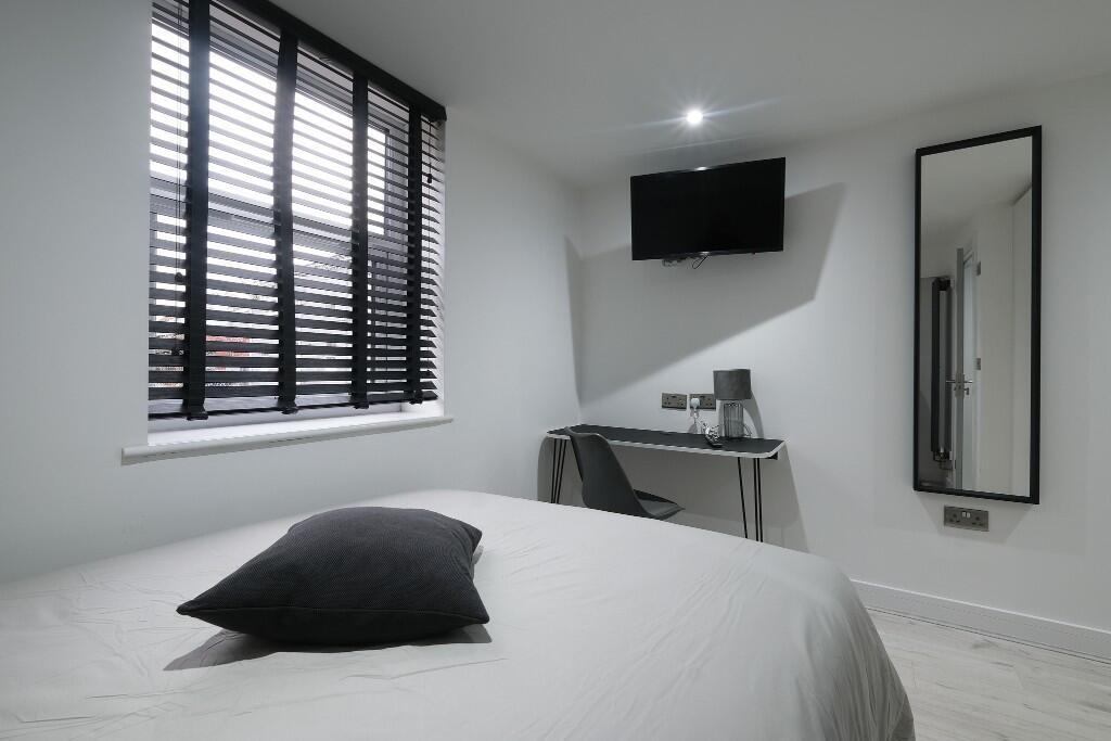 A bright and modern bedroom featuring a neat be...