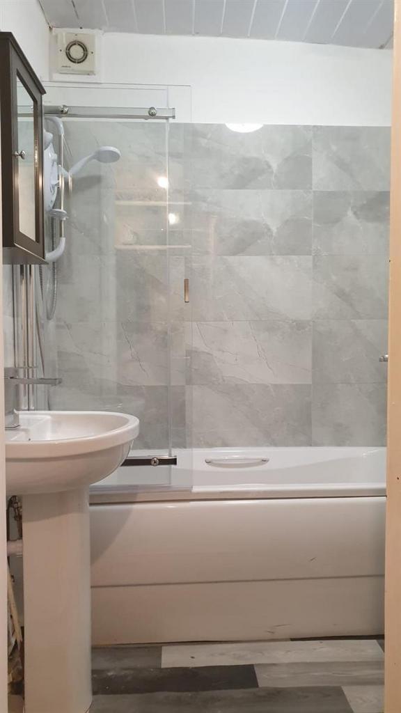 Bright, modern bathroom featuring a bath with i...