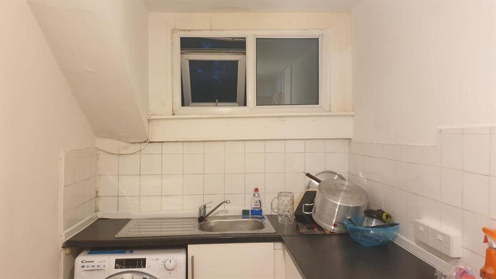 Compact kitchenette with a countertop sink, bui...