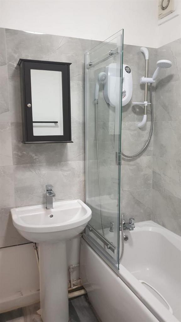 Bright, modern bathroom featuring a bathtub wit...