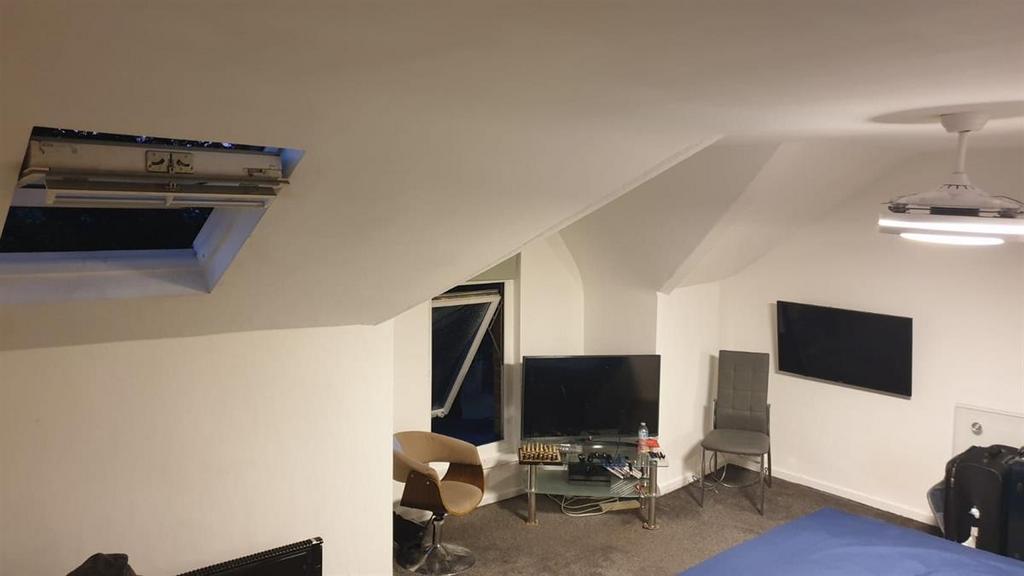 Cozy attic-style double bedroom with sloped cei...