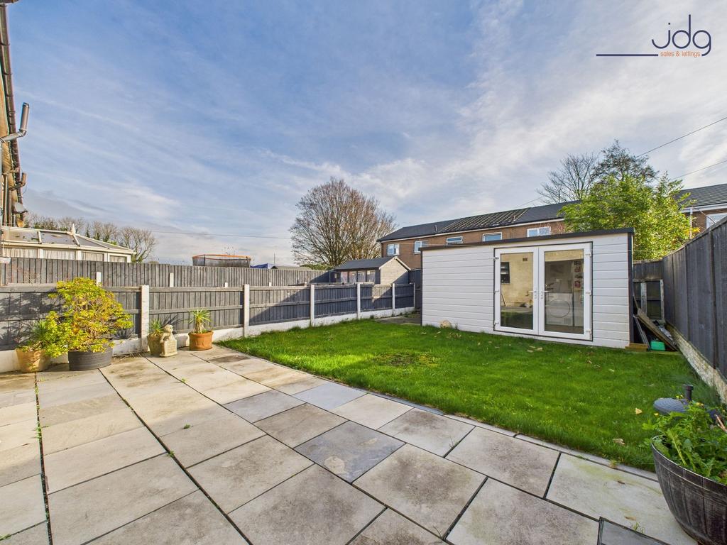 Generous garden combining lawn and paved areas.