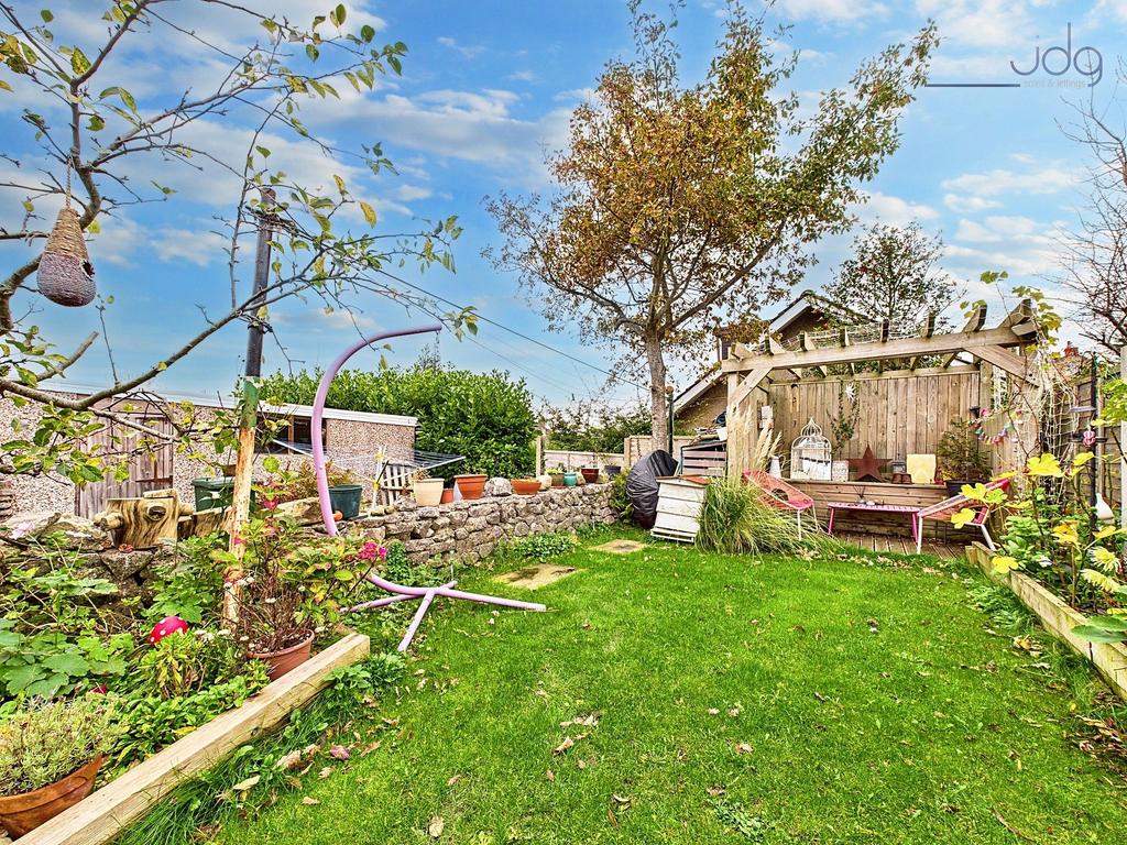 A ginnel separates the yard from the property’s...