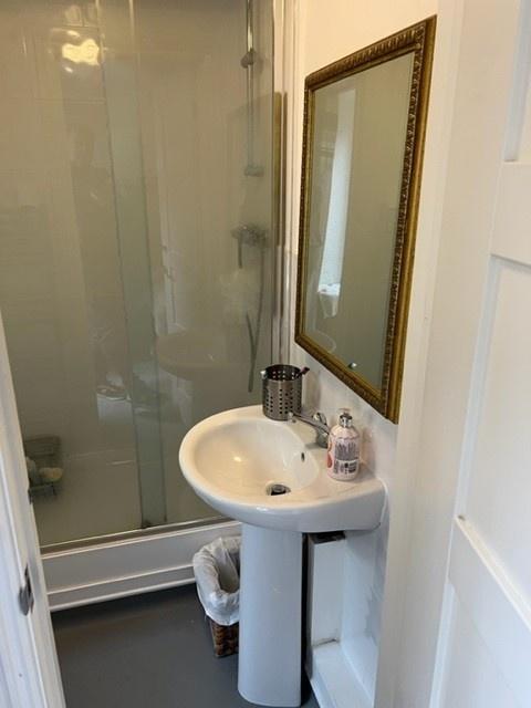 Bright, tidy bathroom featuring a walk-in showe...