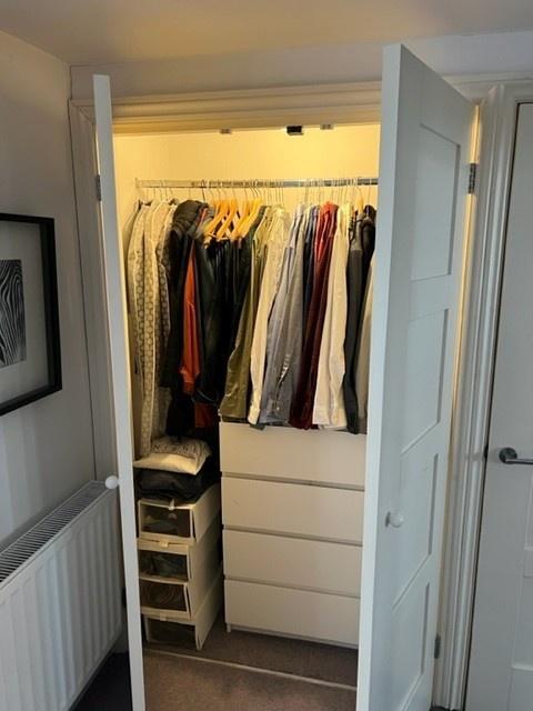 Well-organised bedroom wardrobe area with built...