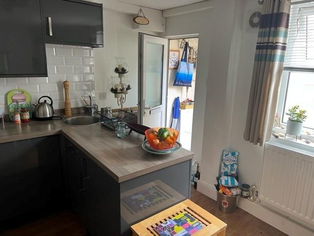 Bright modern kitchen with dark cabinetry, wood...