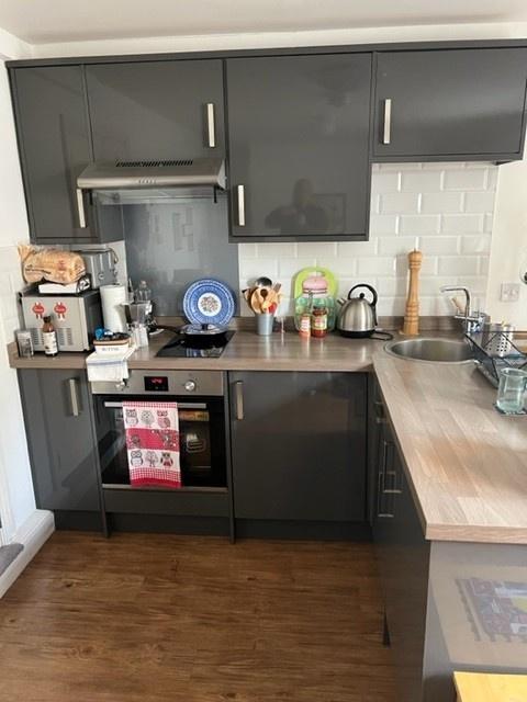 Modern fitted kitchen with glossy dark cabinets...