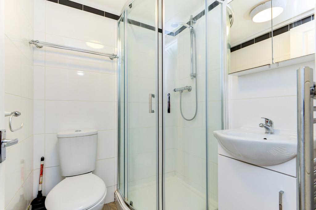 Bright, modern bathroom with a corner glass sho...