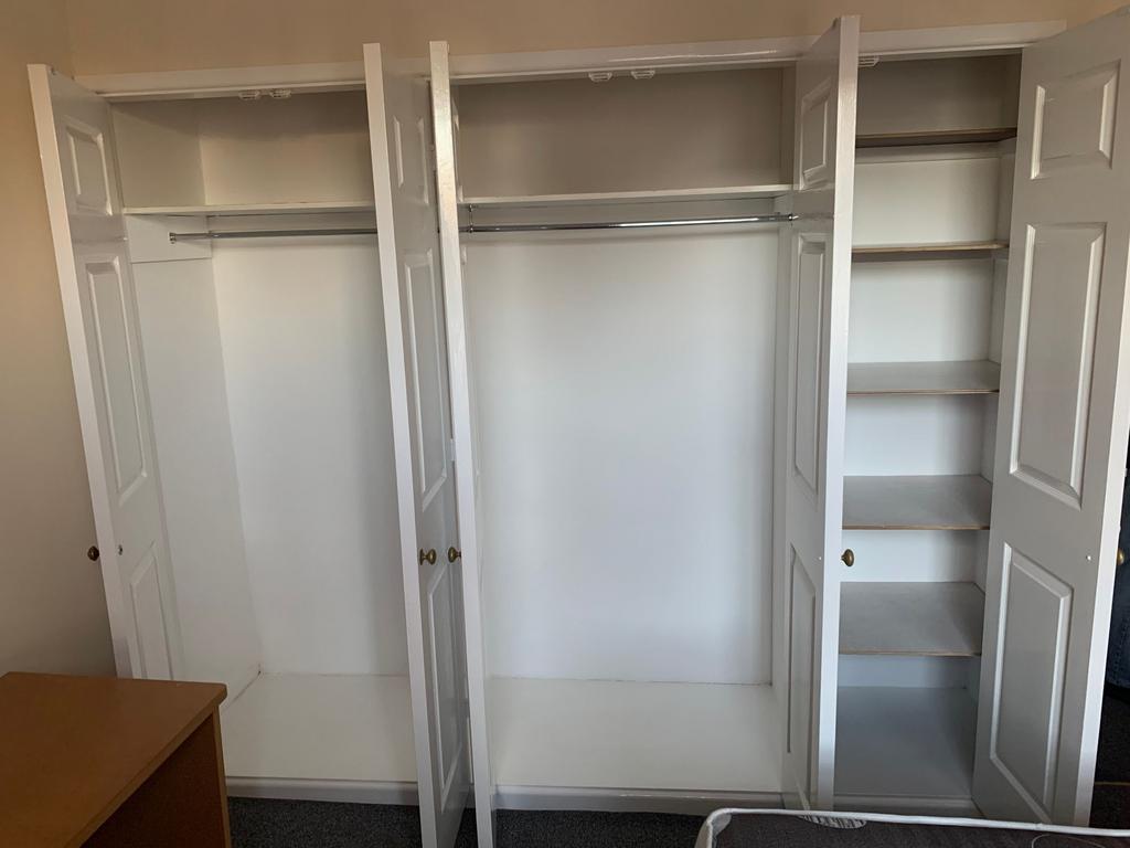 Bright built-in wardrobe with multiple hanging ...
