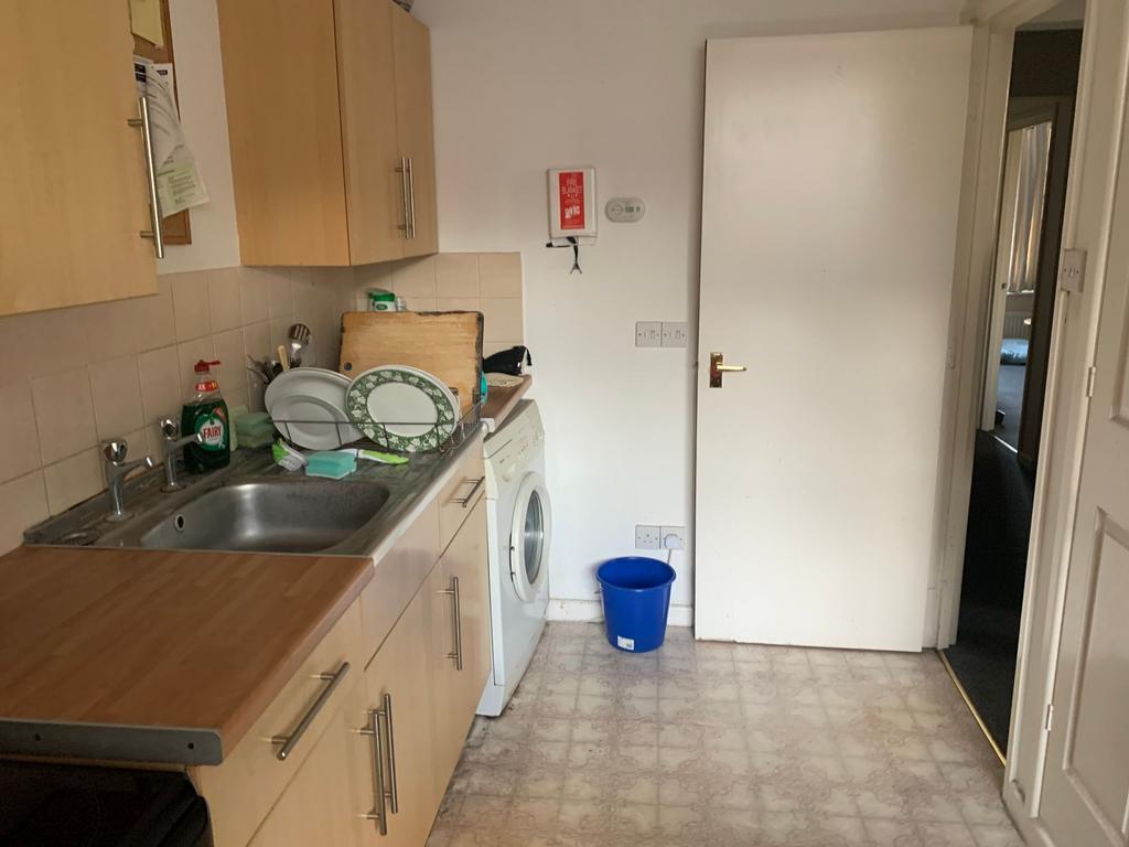 Practical galley-style kitchen with light wood ...