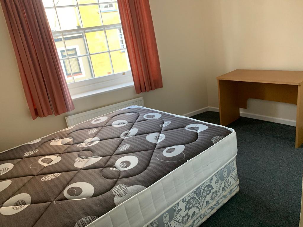 Bright, simply furnished bedroom with a large s...