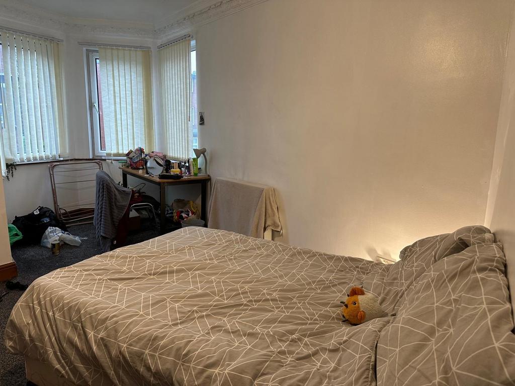 A cozy bedroom featuring a comfortably made dou...