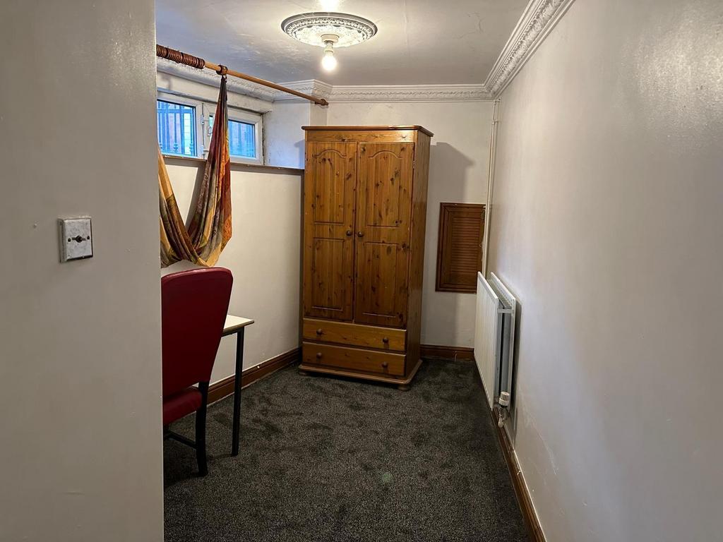 A cozy bedroom featuring a wooden wardrobe, a w...