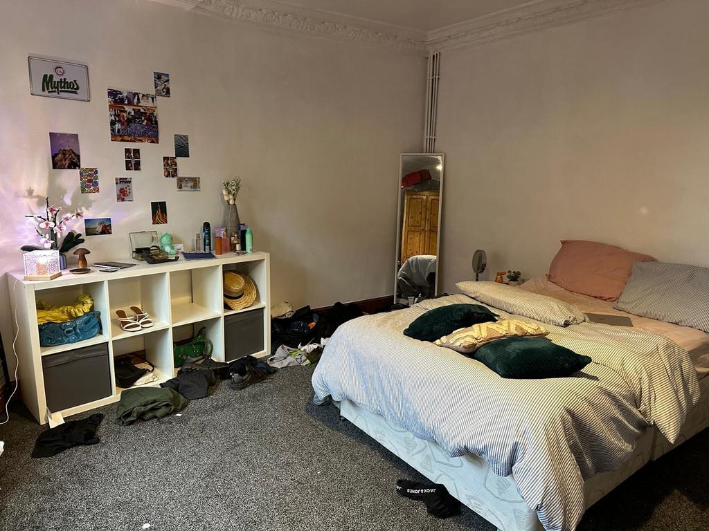 A cozy bedroom featuring a double bed with pill...