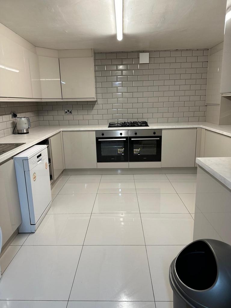 A modern, bright kitchen with white cabinetry a...