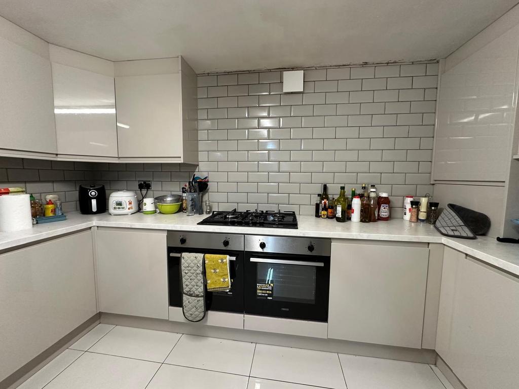 A modern, clean kitchen with white cabinets and...