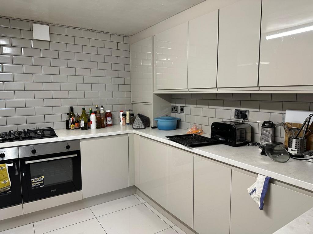 Modern and clean kitchen with white cabinetry, ...