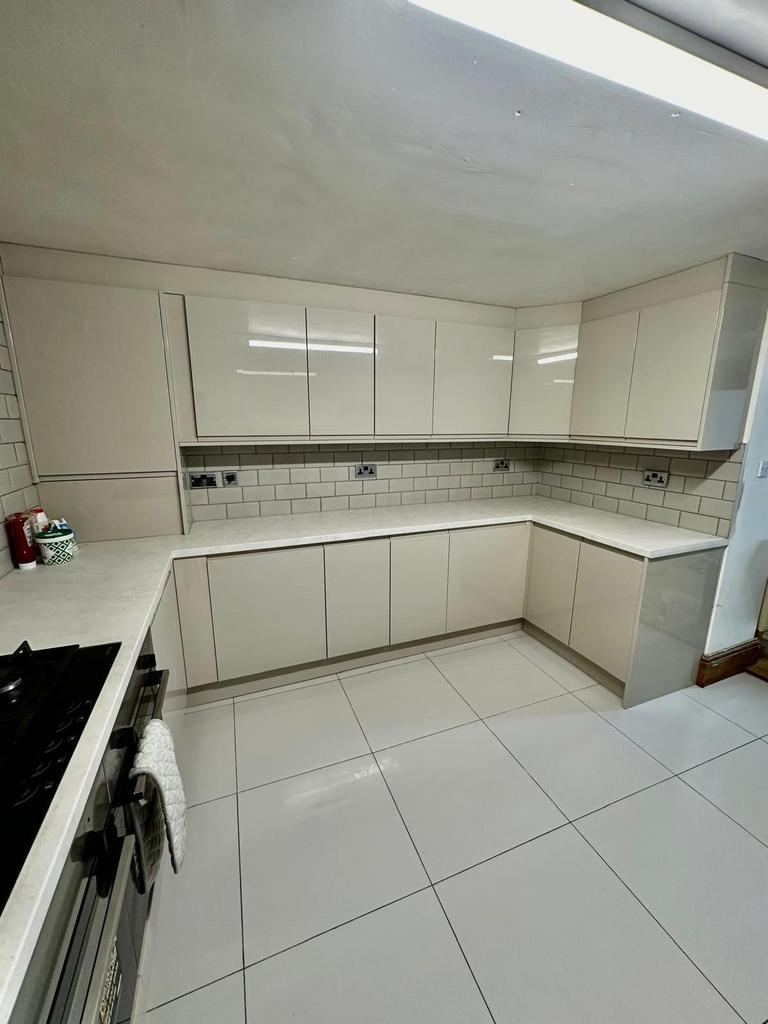 Modern and clean kitchen with ample white cabin...
