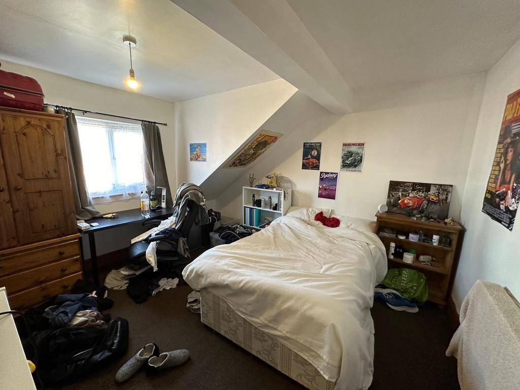 A cozy bedroom featuring a double bed with a wi...