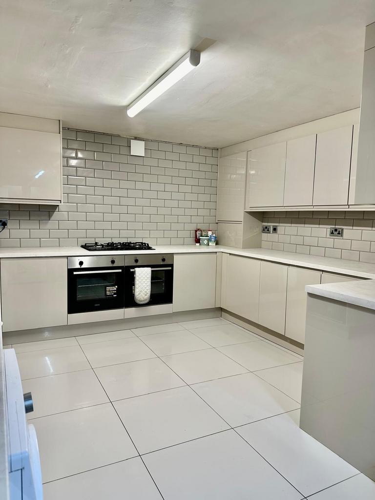 A modern, clean kitchen with white cabinetry an...