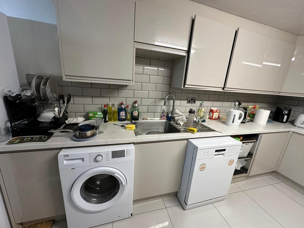 A modern kitchen featuring white cabinetry and ...