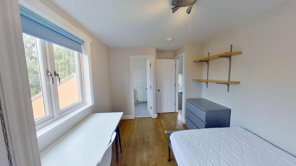 Bright, neatly presented bedroom with a large w...