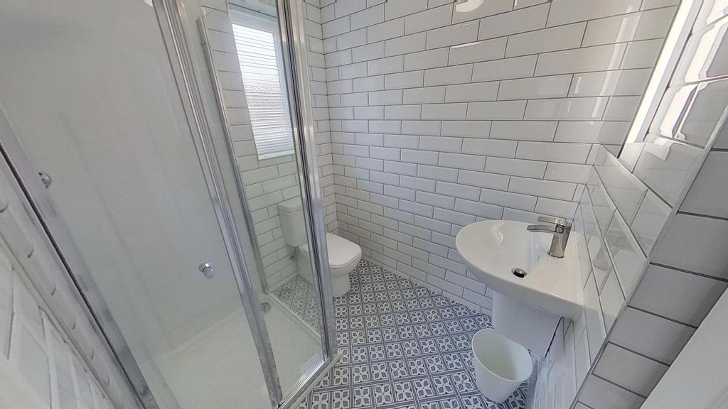 Bright, modern bathroom with patterned tiled fl...