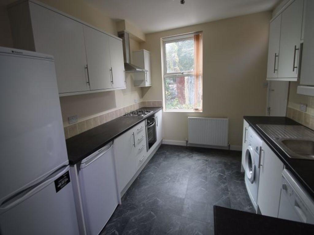 Bright galley-style kitchen with white cabinetr...