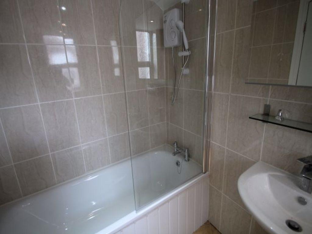 Bright, modern bathroom with a bathtub and show...