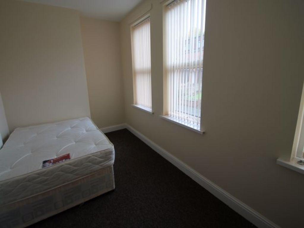 Simple, clean single bedroom with two tall wind...
