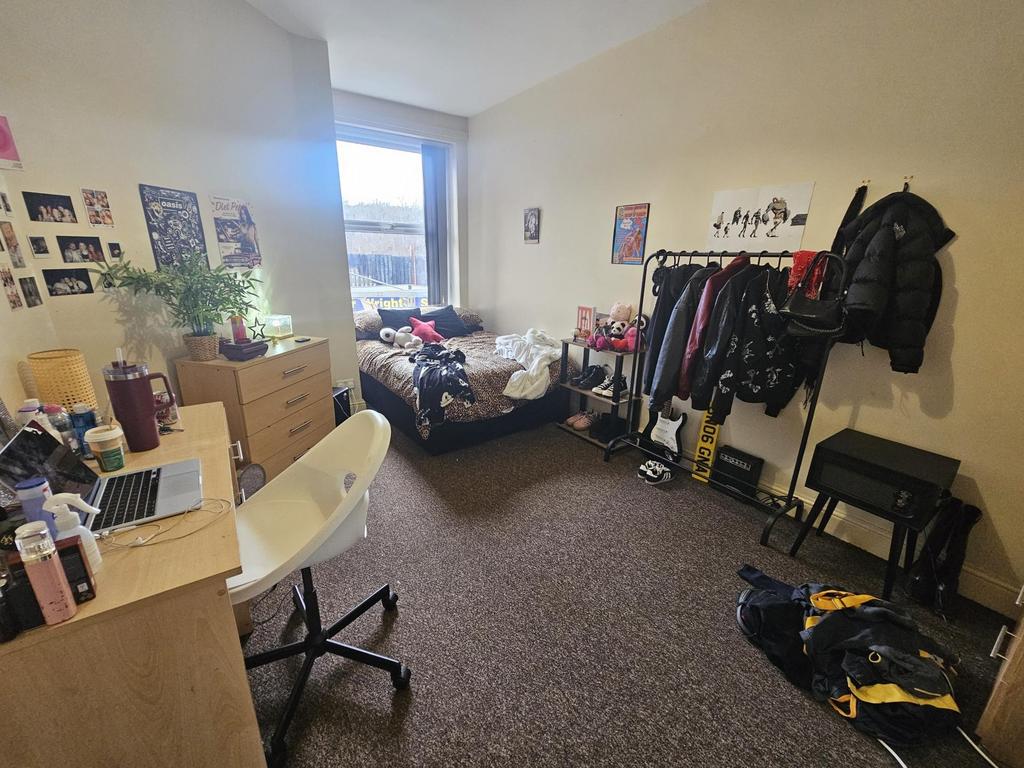Well-lit single bedroom with a large window, fu...