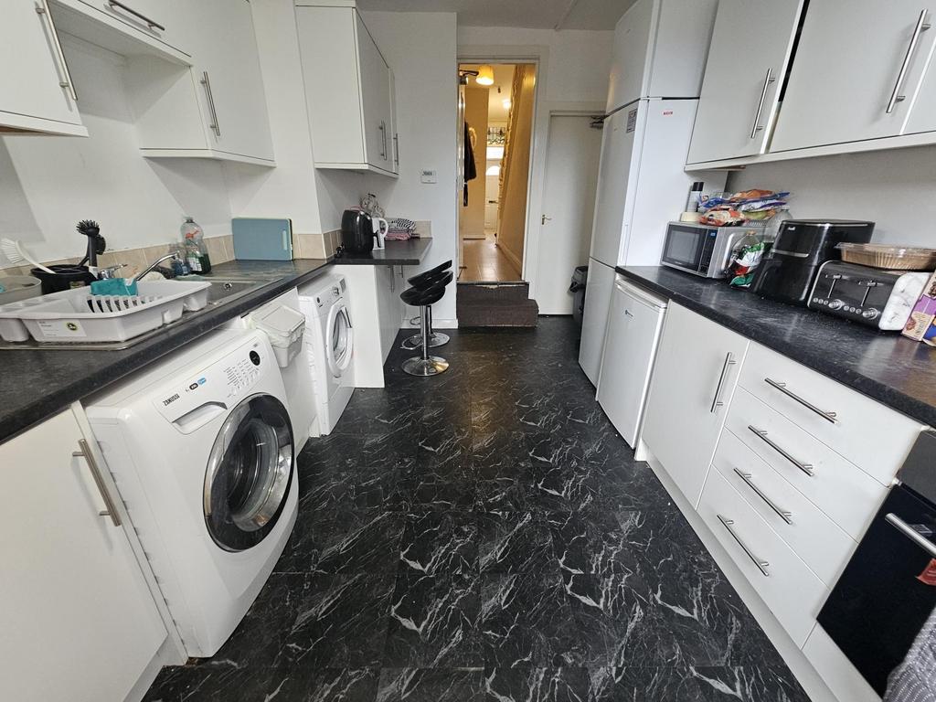 Long galley kitchen with matching white cabinet...