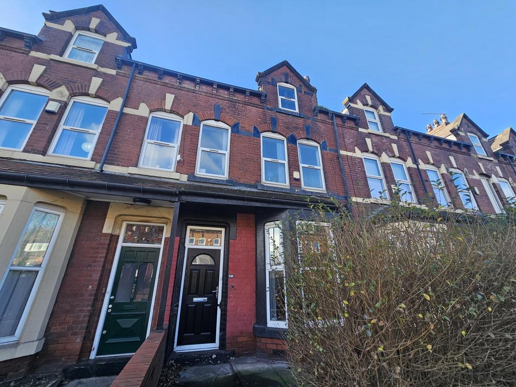 Traditional red-brick terraced house with tall ...