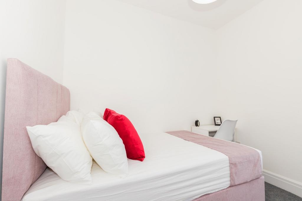 Bright, neatly presented bedroom with a soft pi...